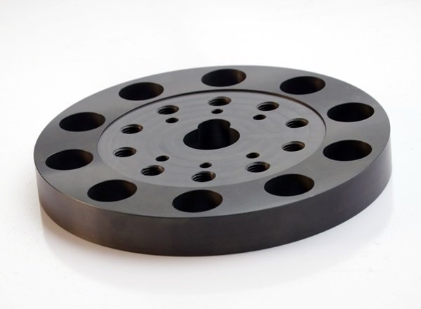 Representative black CNC machined plastic fixture plate