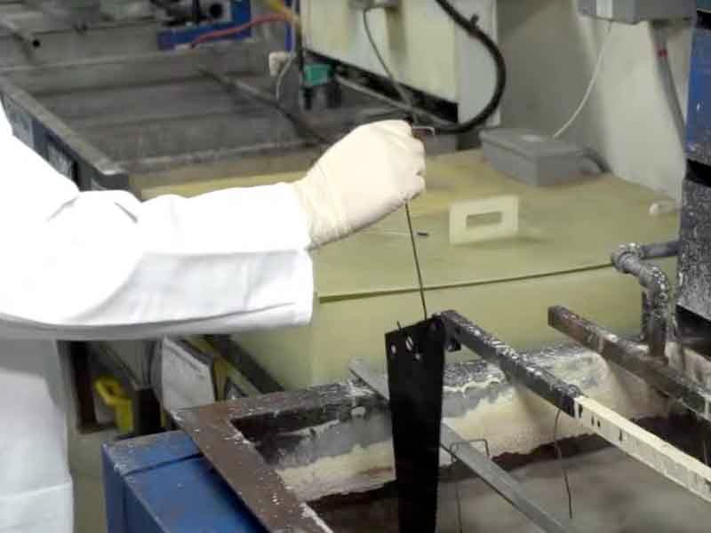 The black oxide coating process showing dipping parts into chemical tanks